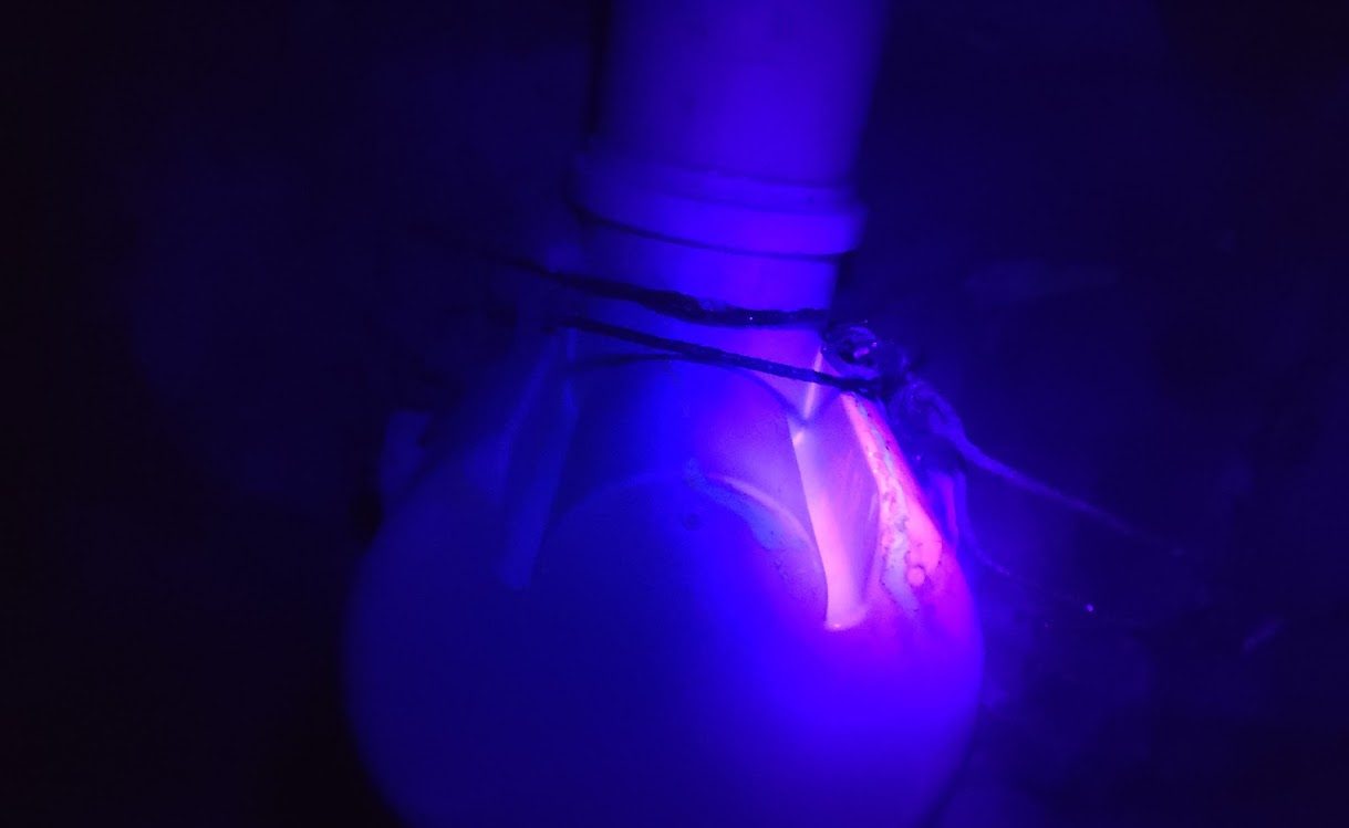 Traçador químico com luz ultravioleta localizando vazamento em conexão